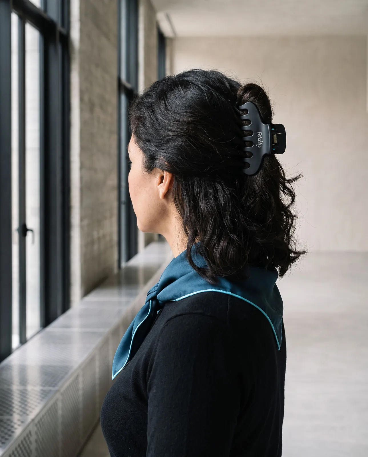 A woman seen from behind wearing the claw clip and the silk square